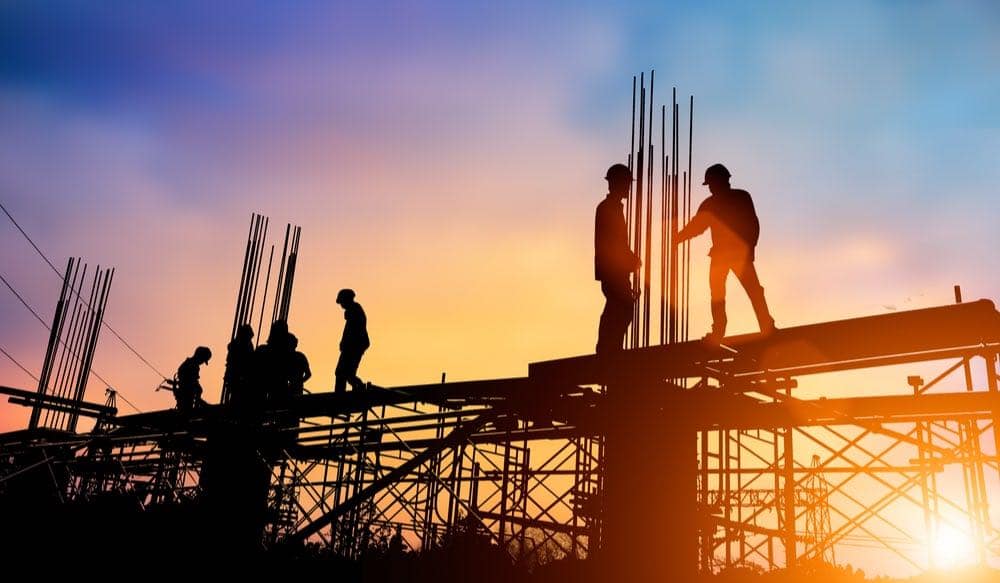 Silhouette of a construction site of workers with the sunset in the background