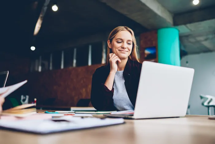 Business woman looking at laptop and smiling