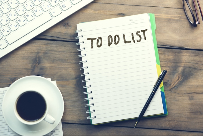 Overhead shot of keyboard, coffee cup, and notepad with empty to do list