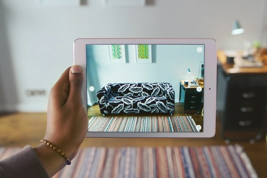 Ikea's augmented reality technology on an tablet showing a customer what one of their couches would look like in the customer's home. 