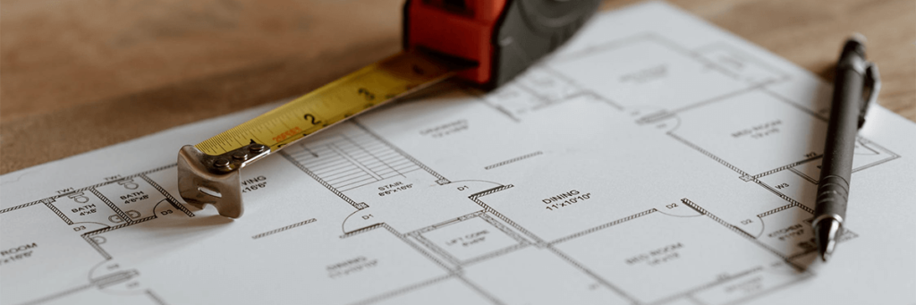 closeup of blueprints with a pencil and measuring tape