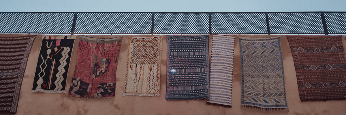 carpets hanging on a wall outside
