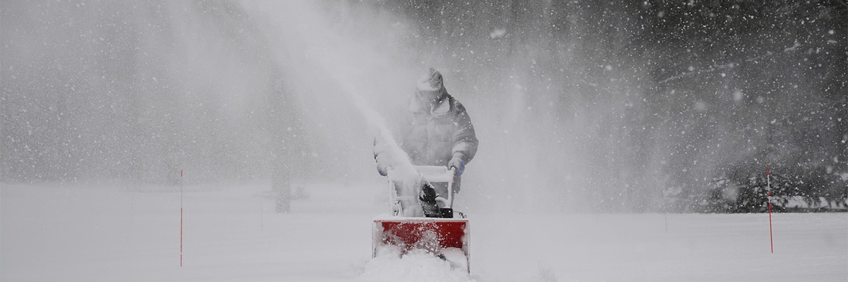 Person pushing a snowblower.