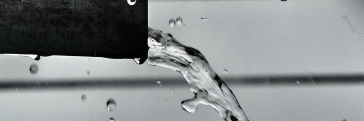 Close up of water flowing out of a pipe.