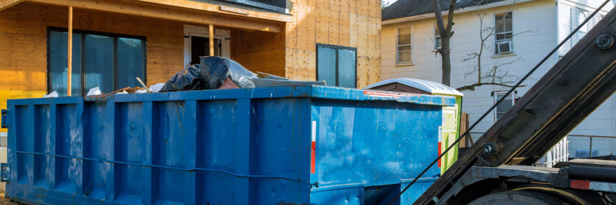 Large blue garbage bin at a construction site