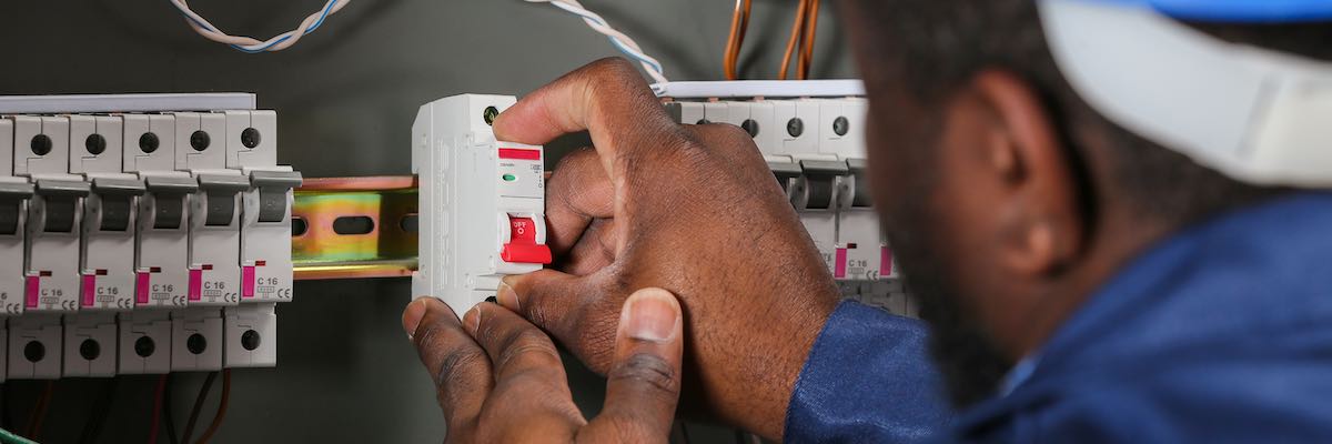 Electrician performing wiring in distribution board