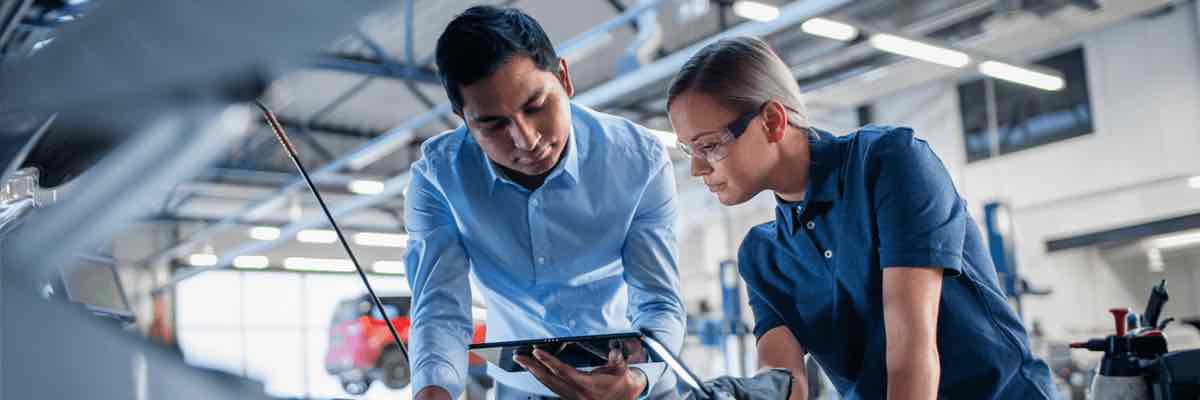 Instructor with a Tablet Computer is Giving a Task for a Future Mechanic