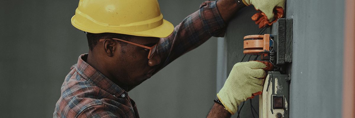 architect with hard hat at a building site looking at electrical thing