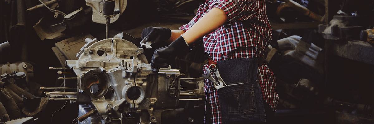 Woman in Yellow Hard Hat Fixing Vehicle Part