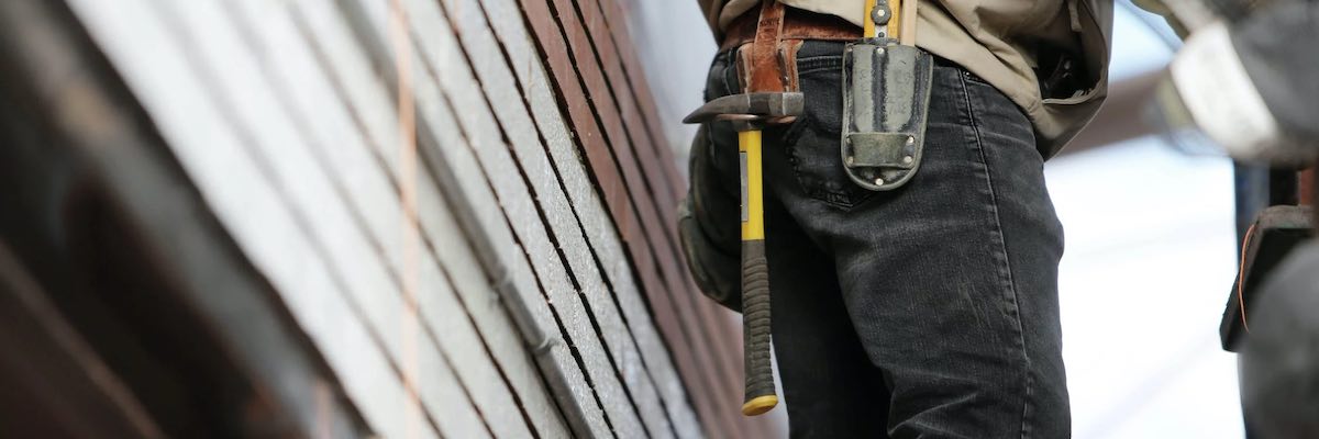 Man Wearing Black Denim Pants With Carrying Hammer on Holster