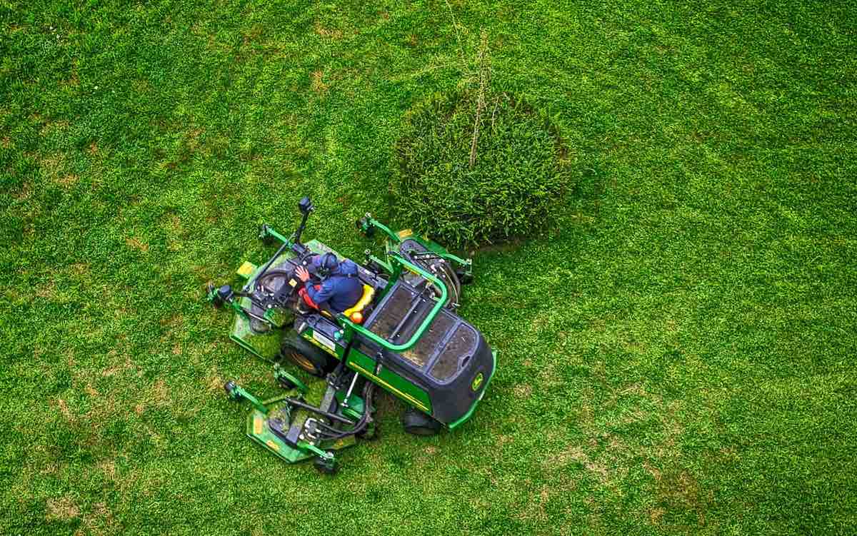 green and black ride on lawn mower on green grass field during daytime