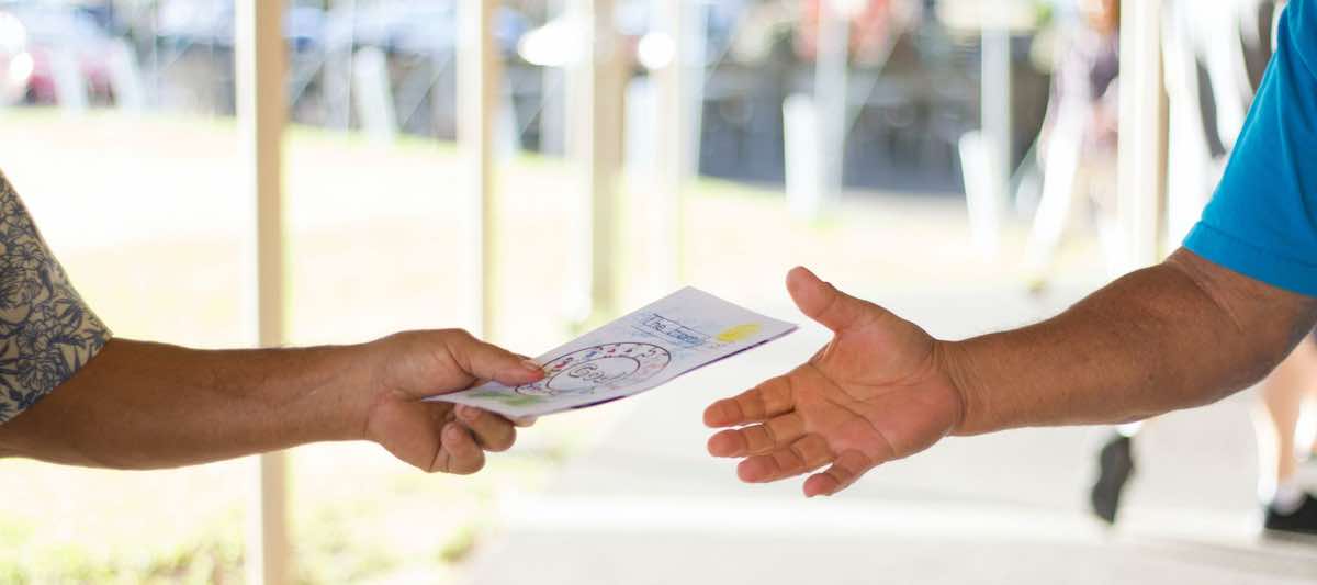 Volunteer handing bulletin