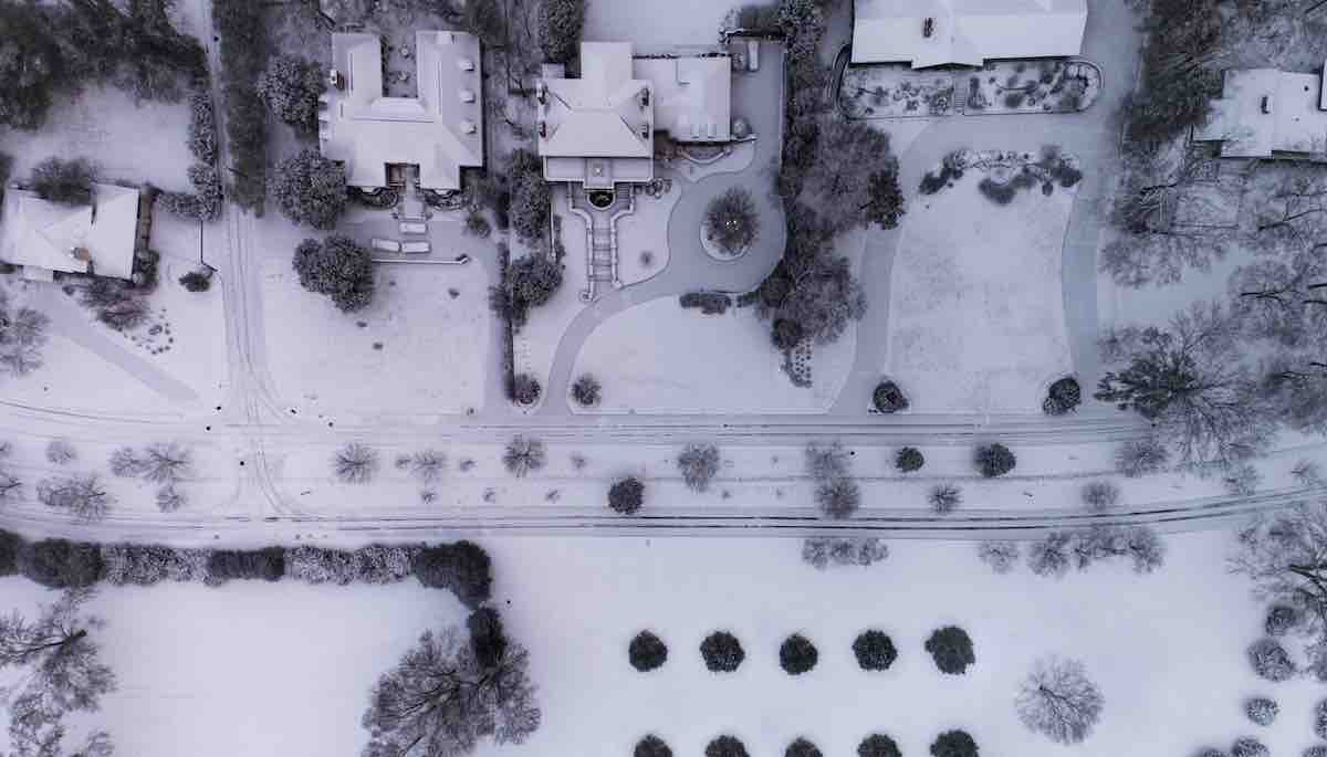 aerial shot of snow capped field near buildings