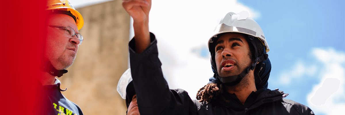 man in black jacket wearing yellow hard hat