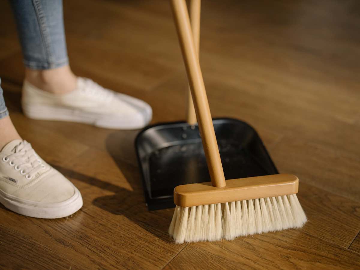 Broom and dustpan being used