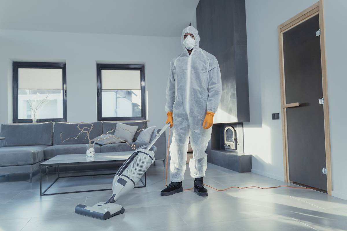 Man in a room vacuuming a room