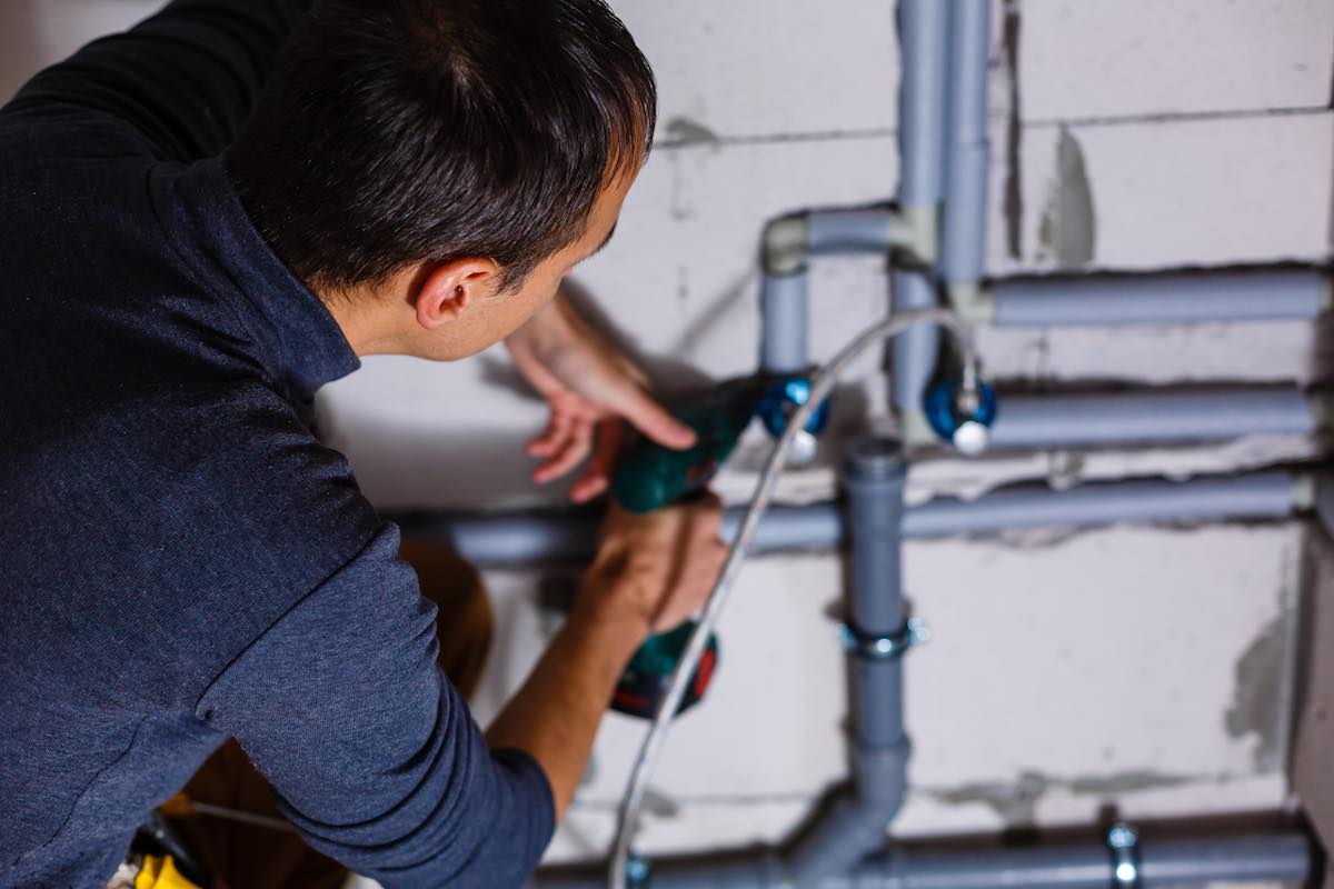 Close-up Of A Male Plumber repairing pipes