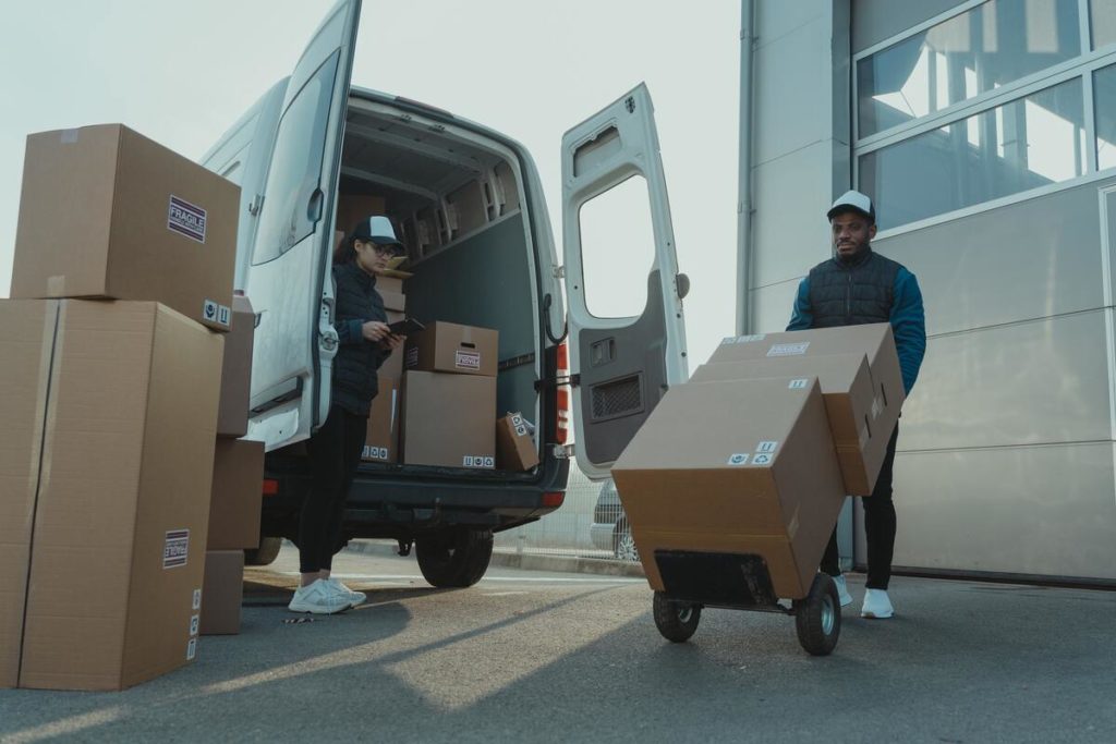Man and a woman loading boxes into a van.