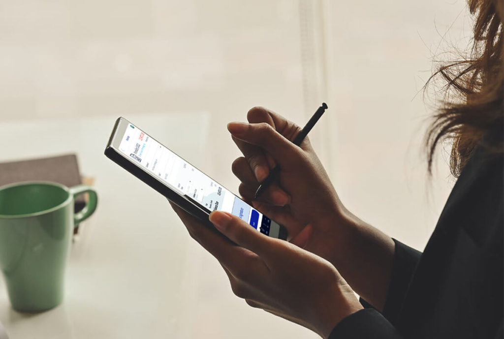 This image shows a woman signing an invoice on her mobile phone through Method CRM's DocuSign integration.