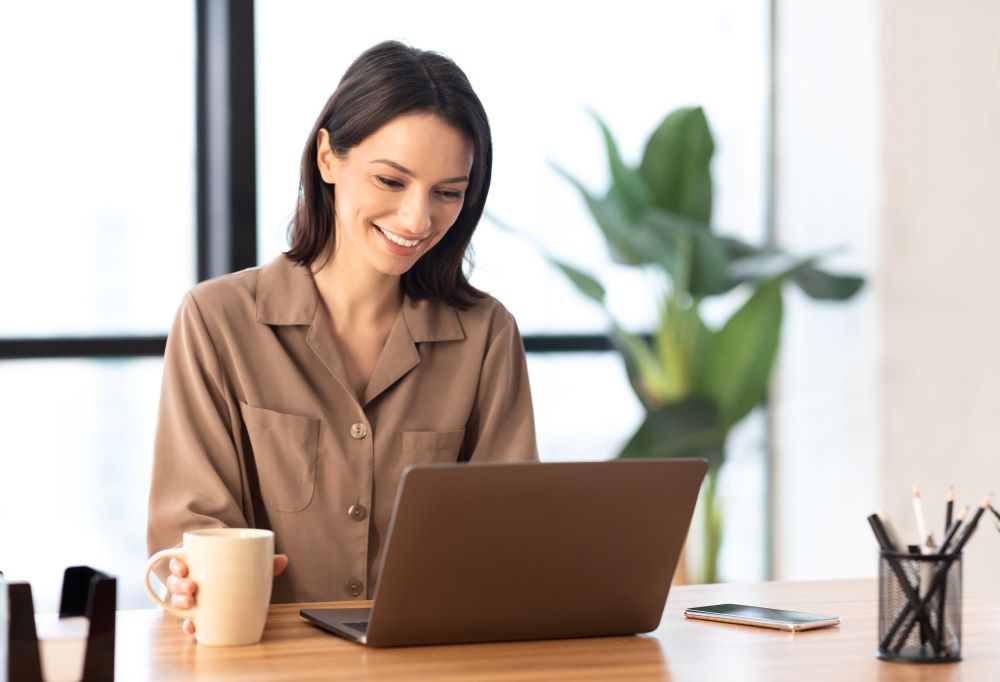 woman-brown-shirt-working-on-laptop