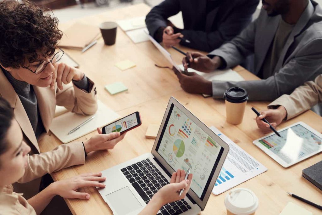 People around a table looking at analytics