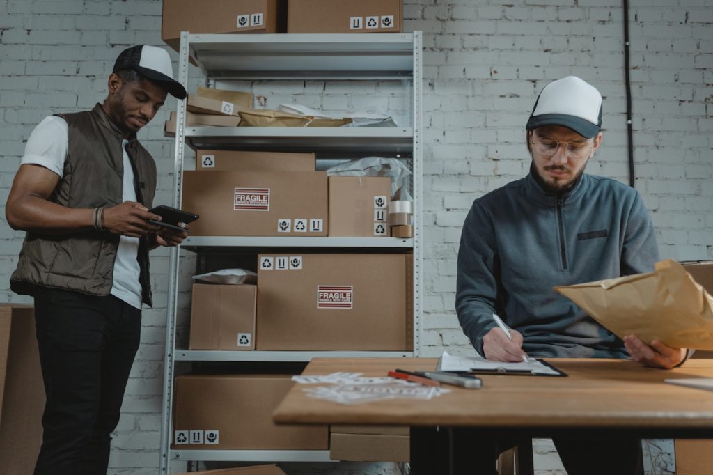 This image shows two workers sorting through packages for distribution.