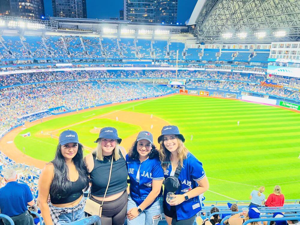 Method team members wearing blue hats and Toronto Jays jerseys, while standing in a stadium.