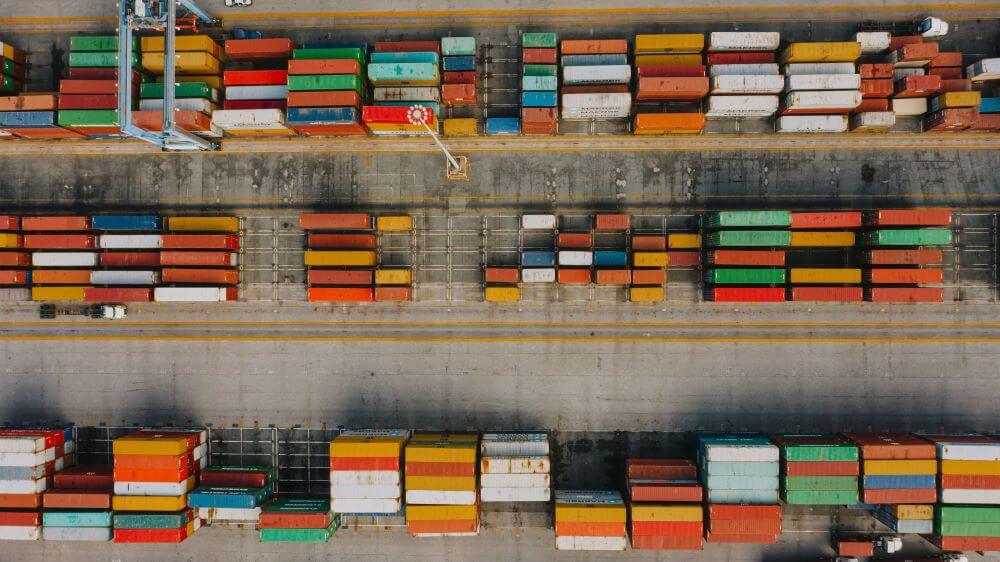 birds-eye view of many bright cargo containers on asphalt