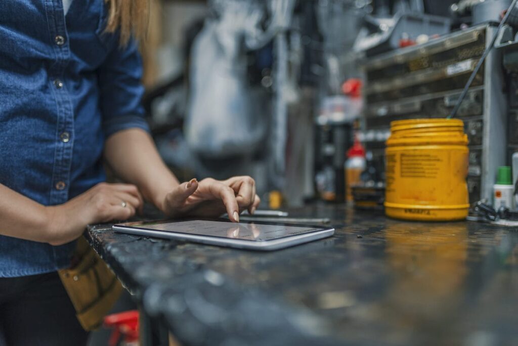 Mechanic uses QuickBooks Online on her tablet at work.