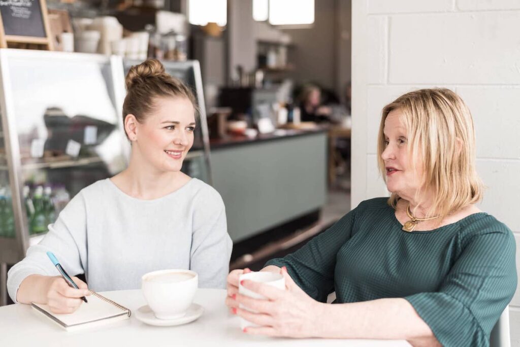 Kayla Prusinski speaking with a client and taking notes.