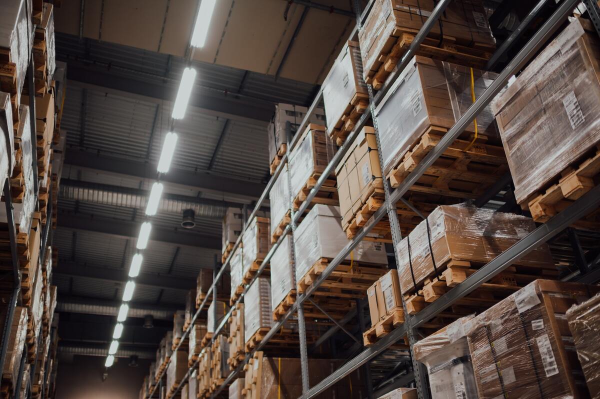 Image of a distribution warehouse aisle, with packed goods stacked on shelves.