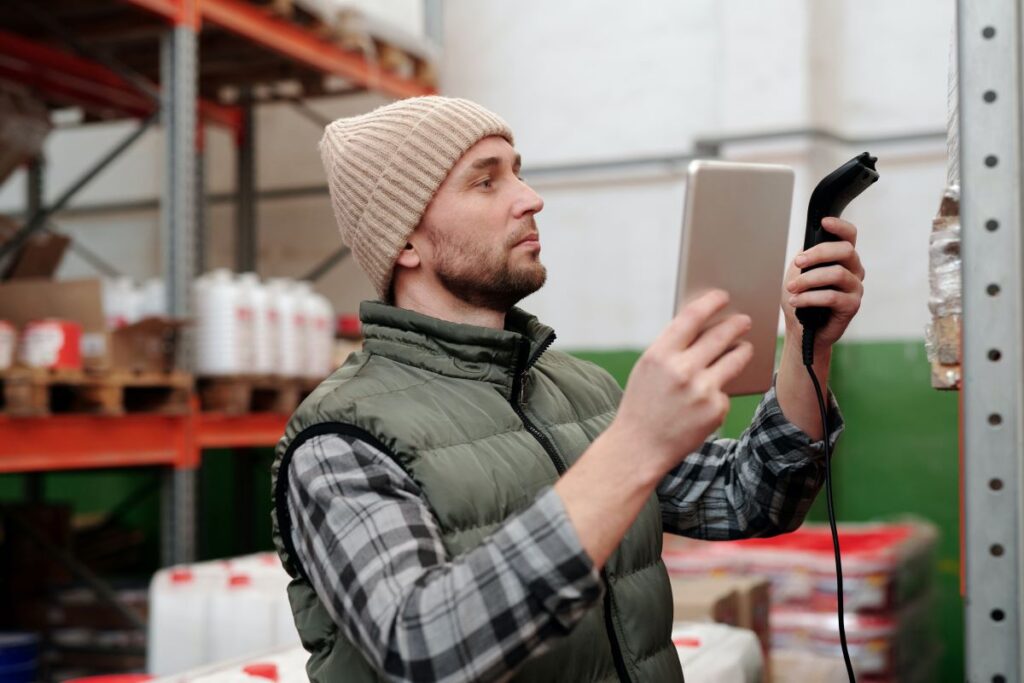 A man tracking inventory with a scanner and tablet.