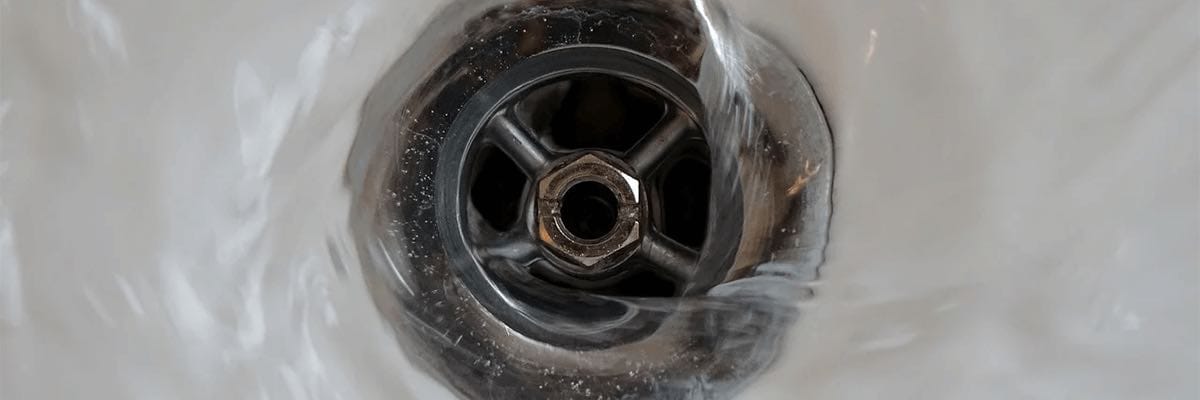Close-up of water going down a sink drain