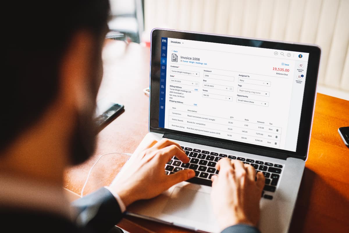 rear view of man typing on laptop looking at a screen with a Method invoice on it.