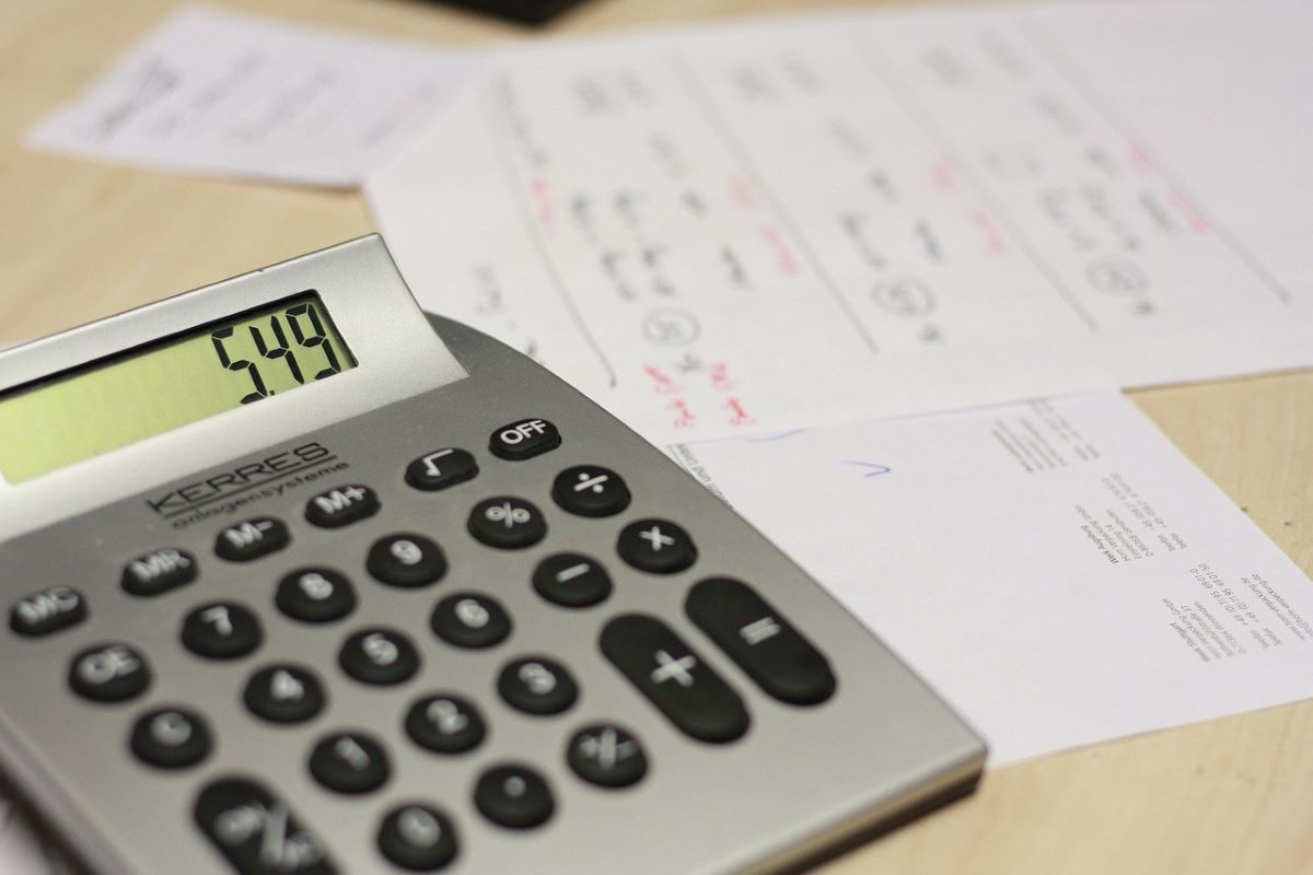 A calculator displaying 5.49 on a desk with cluttered papers.