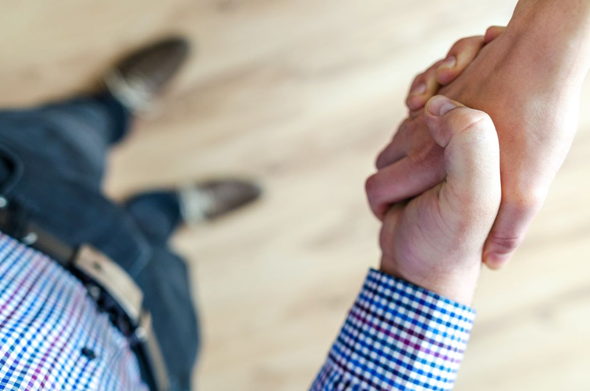 A close-up, overhead shot of two people shaking hands.