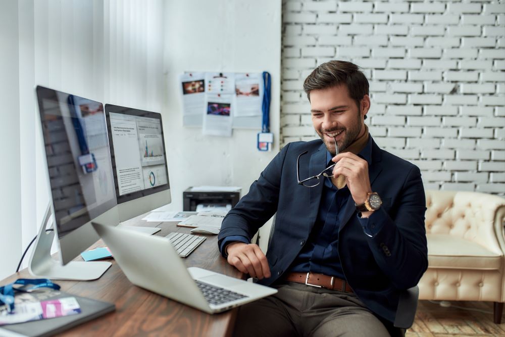 Young man looking at a laptop screen and smiling