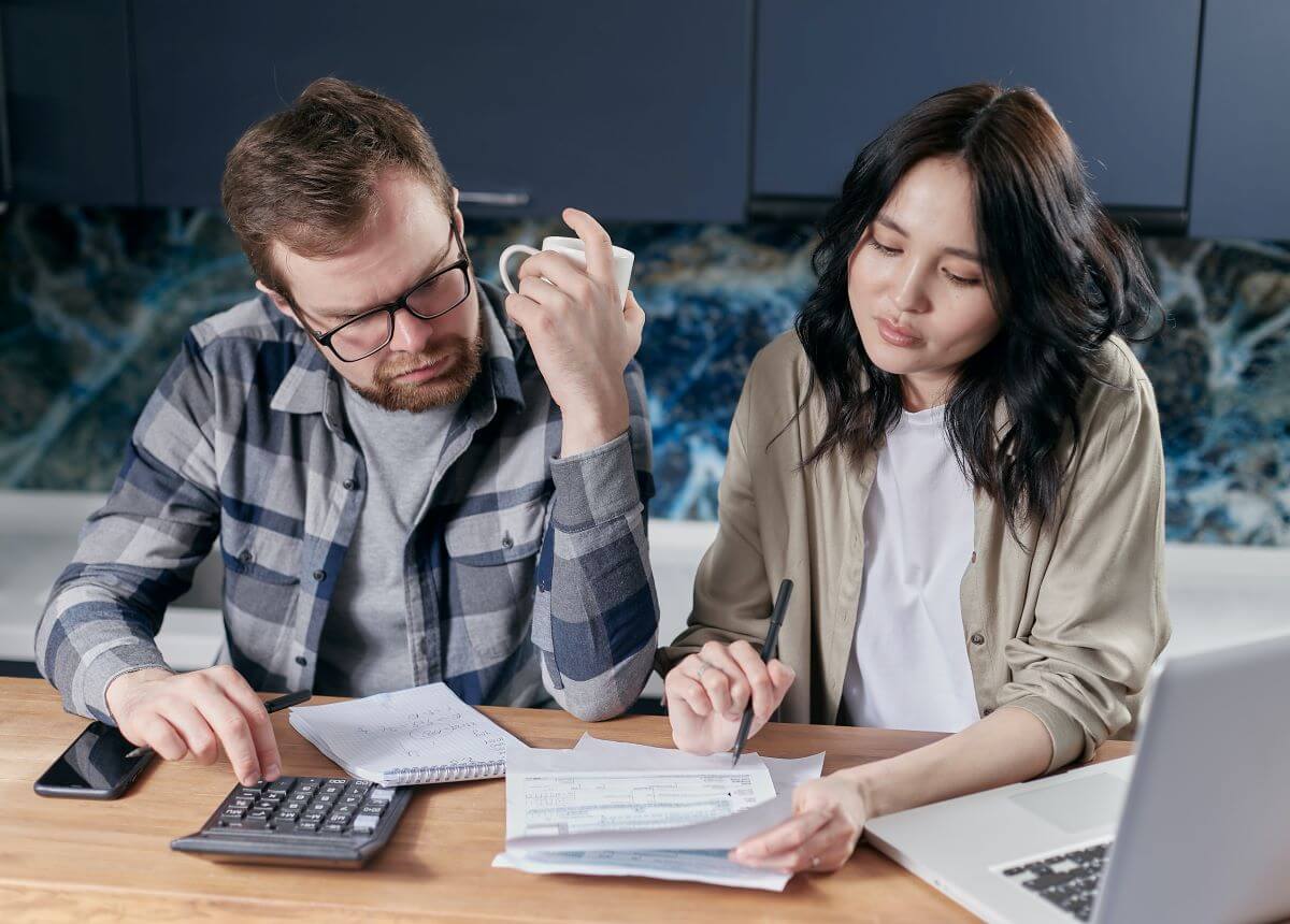 A couple looking at bills with a calculator.