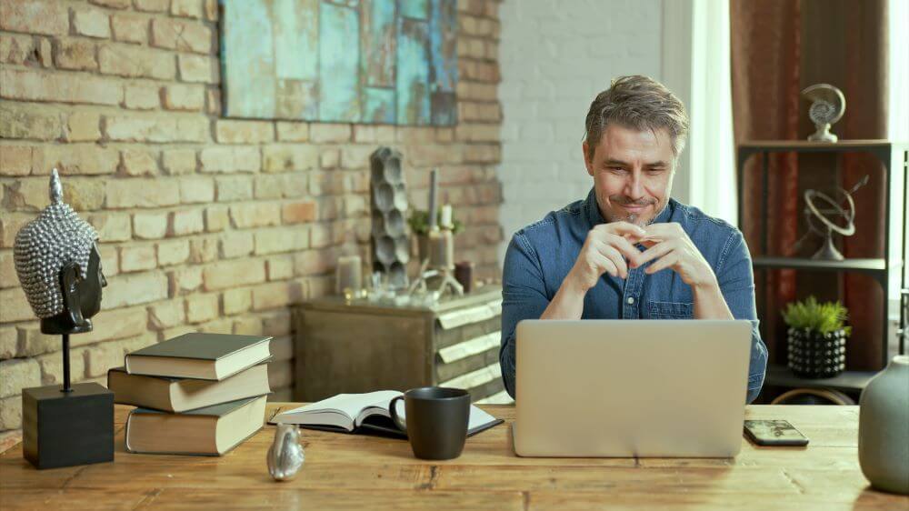 Senior man looking at his computer and smiling.