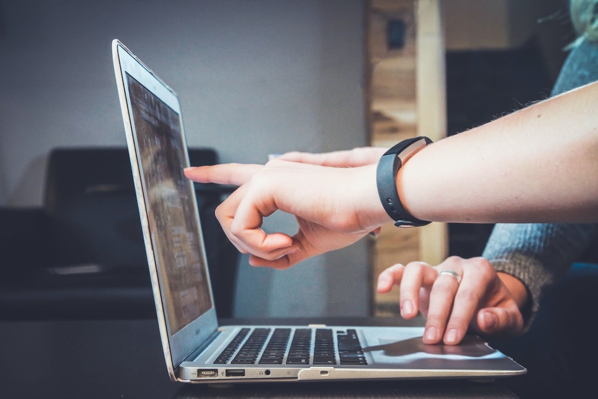 Person pointing at something on computer screen