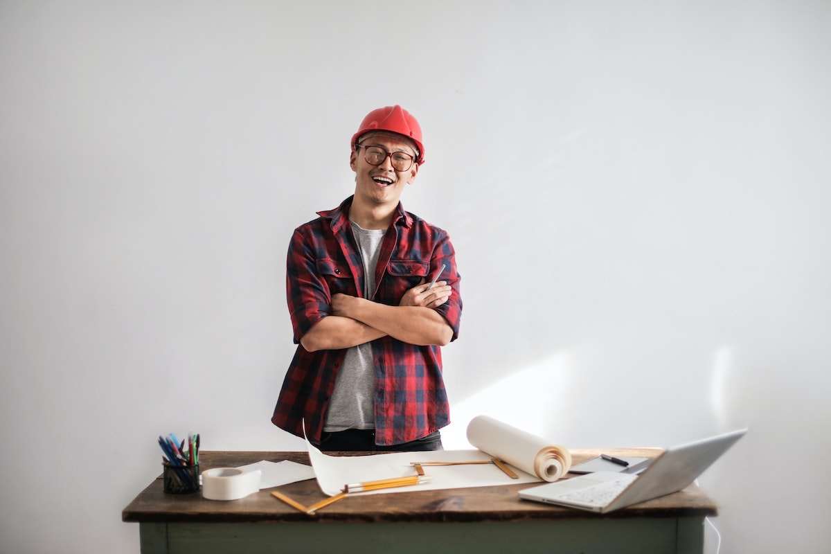 Contractor standing behind a desk full of files