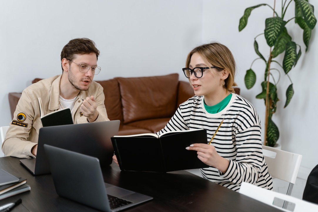 Woman and man discuss computer screens