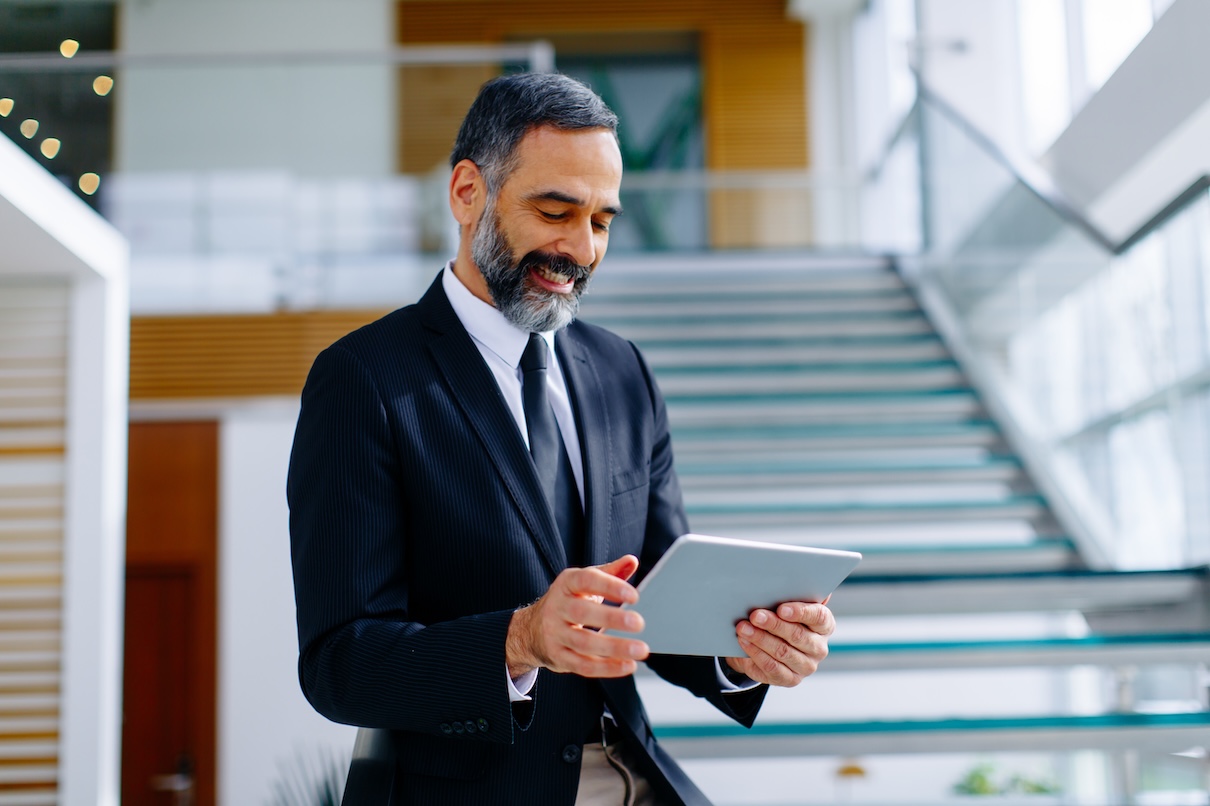 Middle age businessman with digital tablet in modern office