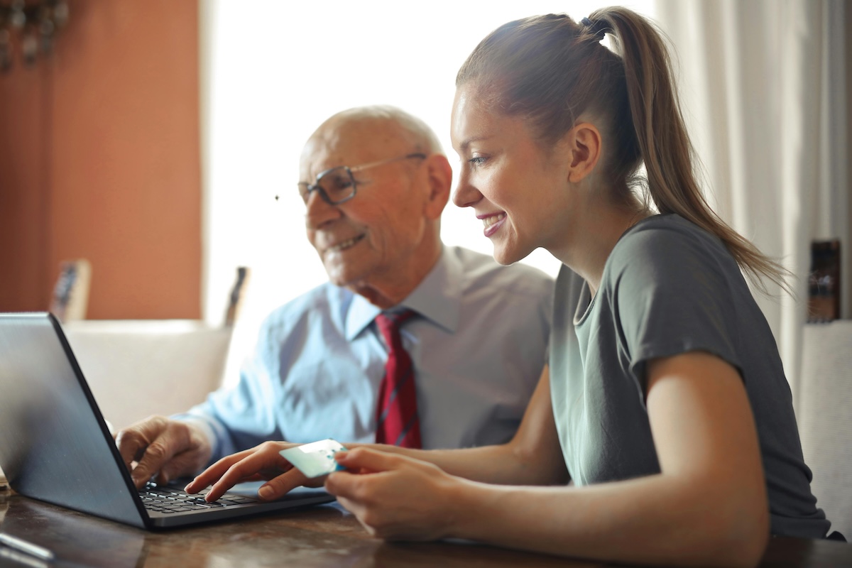 Woman holding credit card and man work on laptop