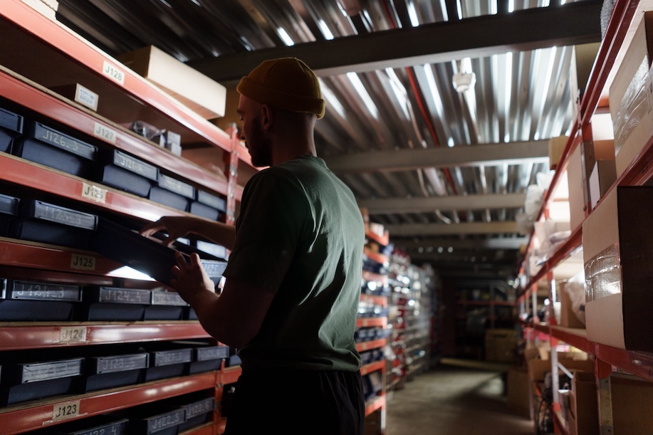 Man in warehouse counts items.