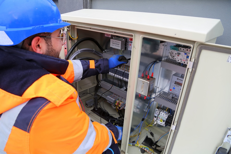 Worker fixes wiring in fuse box.