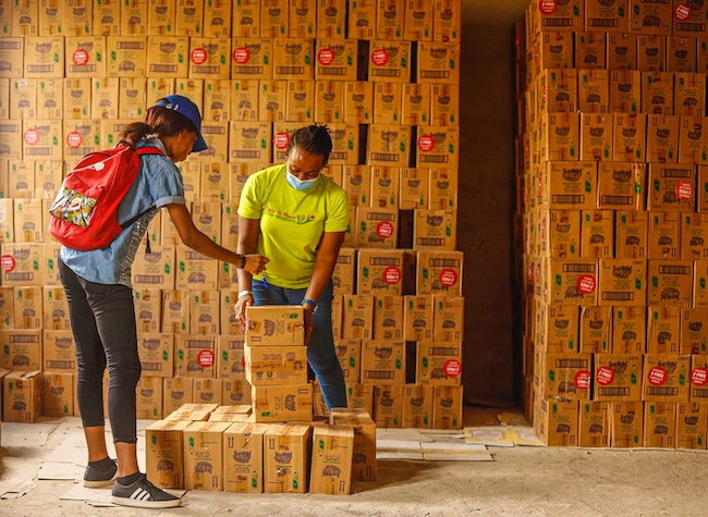 Two women in warehouse count boxes