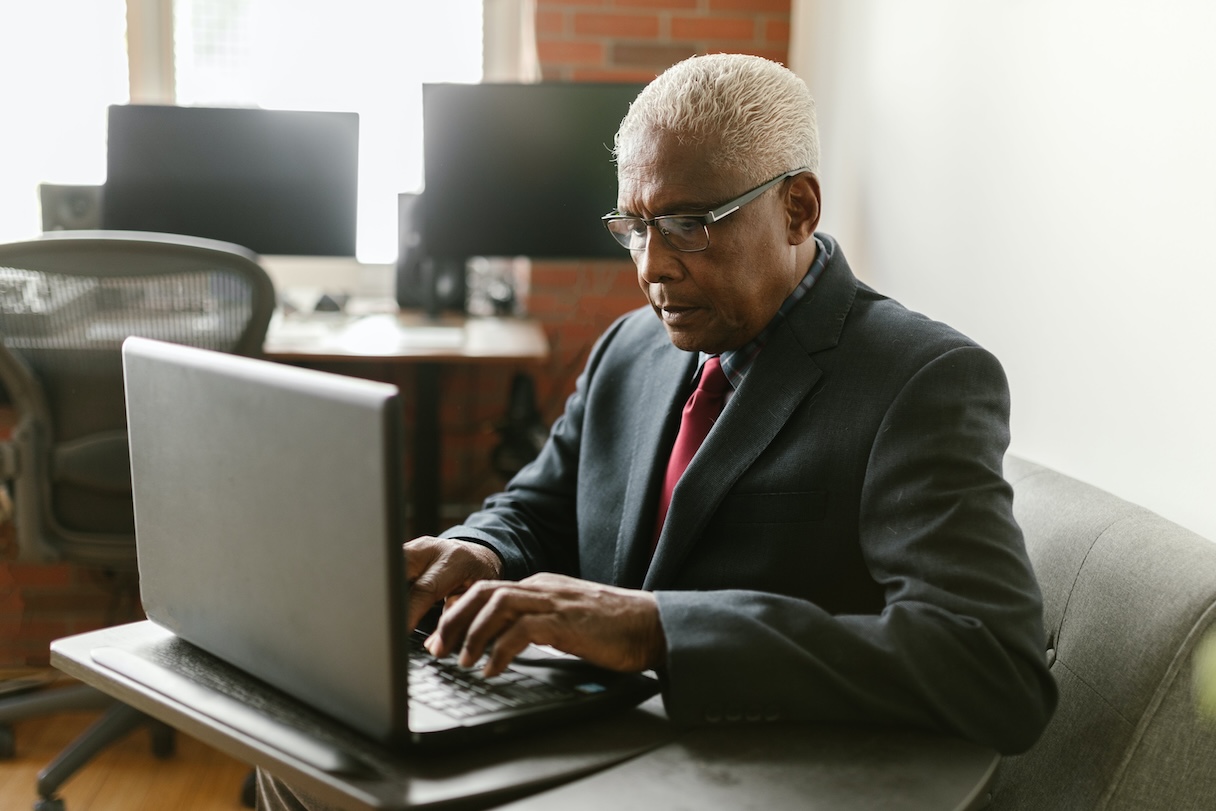 Man sitting on chair working on computer on desk