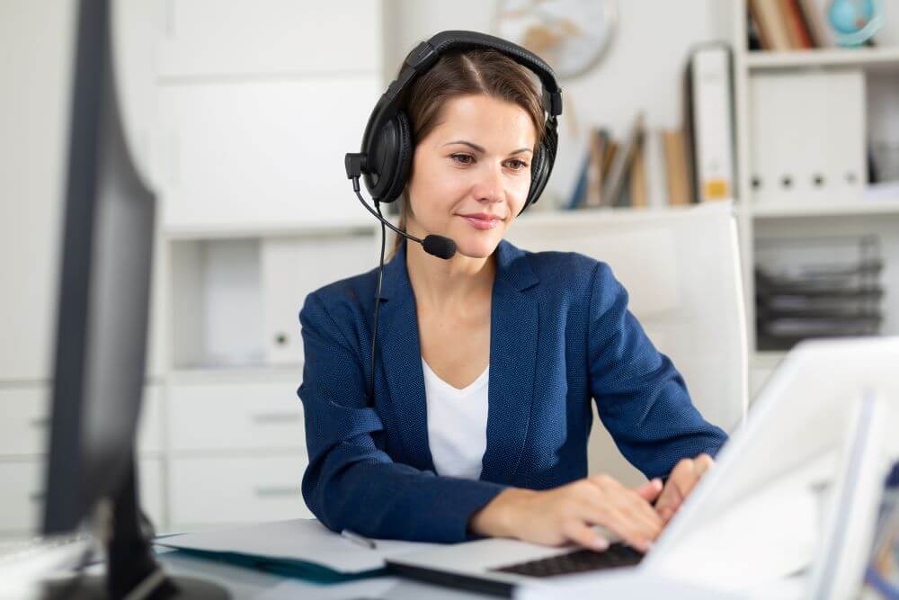 customer service representative wearing a headset and using a laptop