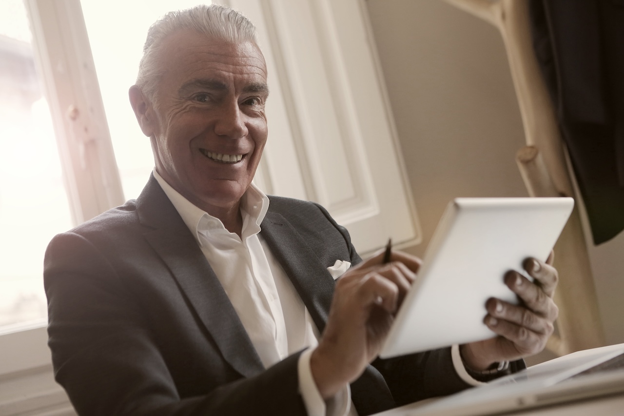 Man In Black Suit Holding A Gadget